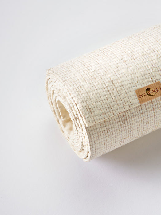 Eco-friendly cream yoga mat by ecoYoga with textured surface, rolled up and shot from the side, displaying brand label.