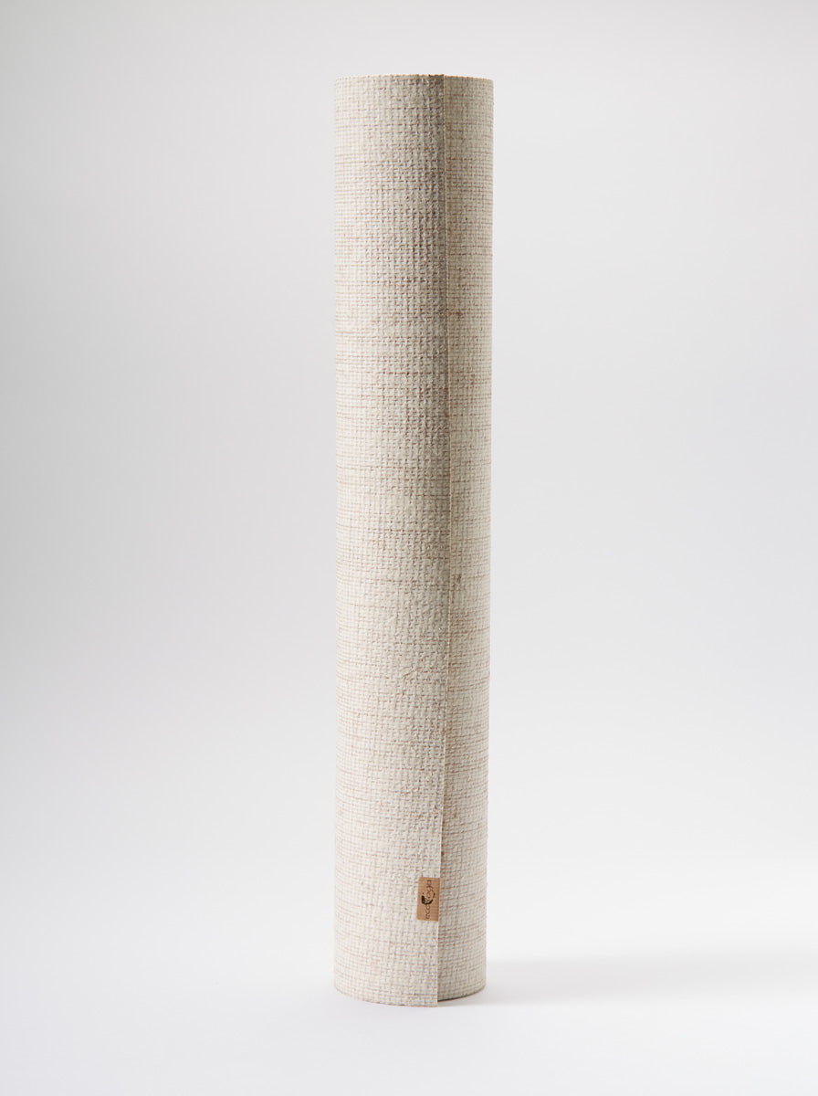 Beige textured yoga mat, full-length side view, with visible brand logo on fabric.