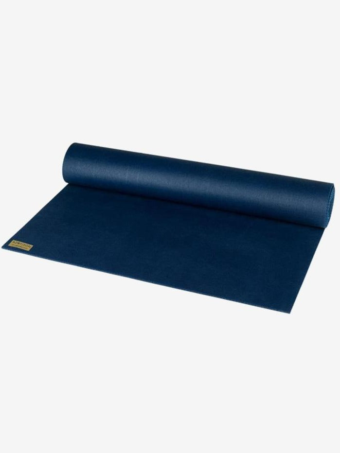 Navy blue yoga mat partially rolled out showing texture and brand label, non-slip exercise mat, durable thick fitness mat side view.