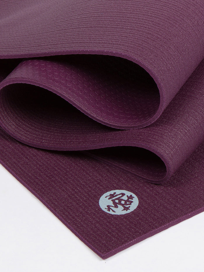 Purple textured non-slip yoga mat partially rolled front view with logo visible.