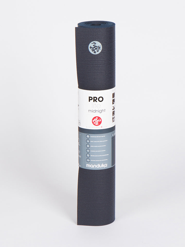 Manduka PROlite yoga mat in midnight color rolled up side view with branded label and texture detail on white background