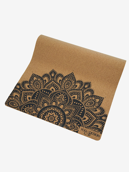 Eco-friendly cork yoga mat with intricate black mandala pattern, side view, non-slip surface, ideal for meditation and fitness routines.